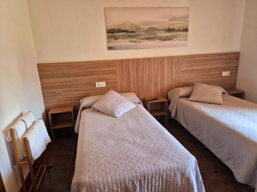 a room with two beds and a painting on the wall at Albergue Rectoral San Mamede da Pena EXCLUSIVE FOR PILGRIMS in Negreira