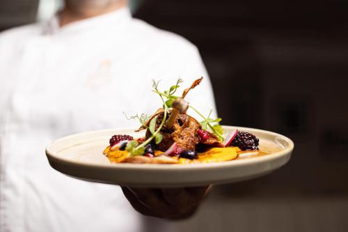 a person is holding a plate of food at Great Southern Killarney in Killarney