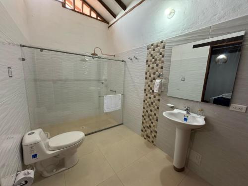 a bathroom with a toilet and a sink and a shower at Hotel Palais Barichara in Barichara