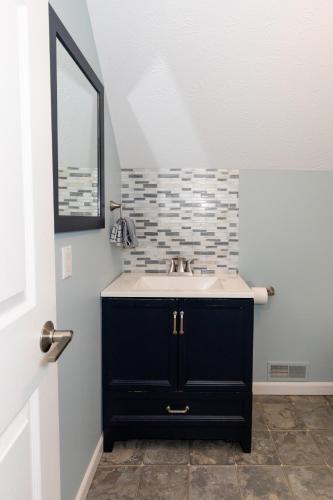 a bathroom with a sink and a mirror at At the Beach - Old Homestead Beach House in Huron