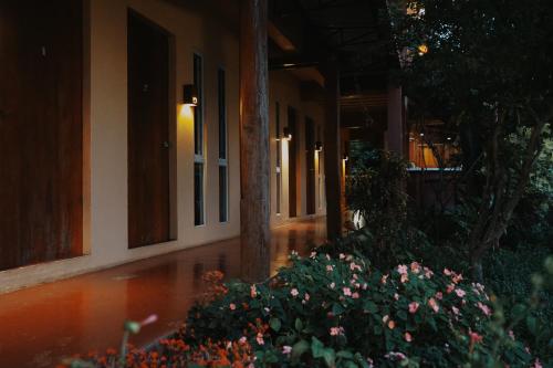 a building with a bunch of flowers in front of it at ComeOn Stay&Sleep in Chiang Rai