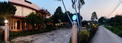 a street in front of a building with a sign at ComeOn Stay&Sleep in Chiang Rai