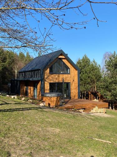 una casa de madera con techo negro en Biebrzaski - dom nad Biebrzą, en Wierciszewo
