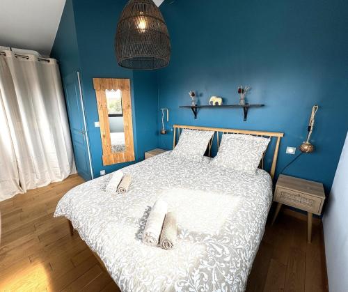 une chambre avec un lit avec un mur bleu dans l'établissement Havre du Bassin avec piscine et studio indépendant, à Gujan-Mestras
