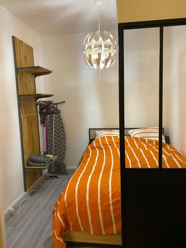 - une chambre avec un lit doté d'une couette orange et blanche dans l'établissement T1 loft spirit, à Clermont-Ferrand