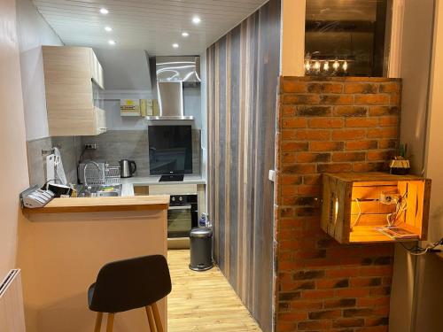 une cuisine avec un mur en briques à côté d'un comptoir dans l'établissement T1 loft spirit, à Clermont-Ferrand