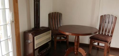 a dining room with a table and chairs and a stove at CEDARS Resorts - Doodhpathri Kashmir in Rengazabal