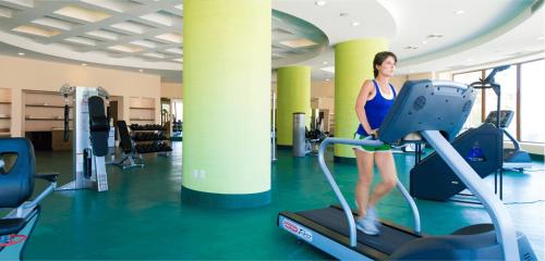a woman on a treadmill in a gym at Villa del Palmar at the Islands of Loreto in Loreto