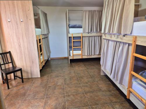 a room with two bunk beds and a chair in it at Albergue Rectoral San Mamede da Pena EXCLUSIVE FOR PILGRIMS in Negreira