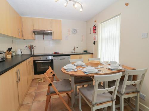 a kitchen with a wooden table and chairs and a table and chairsktop at 26 Manorcombe in Callington