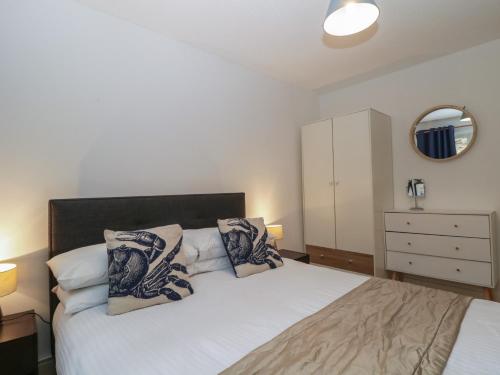 a bedroom with a bed and a dresser with a mirror at 26 Manorcombe in Callington