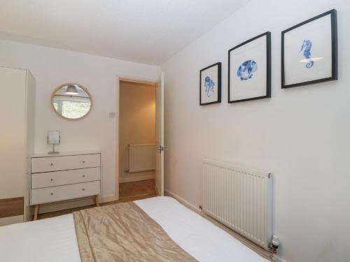 a bedroom with a bed and three pictures on the wall at 26 Manorcombe in Callington