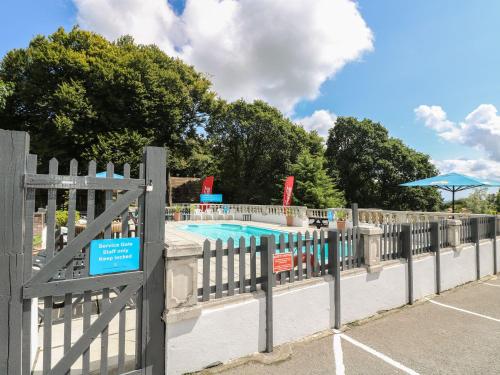 a fence with a swimming pool in a park at 26 Manorcombe in Callington