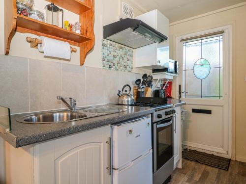 a small kitchen with a sink and a stove at Tench Hut in Uckfield