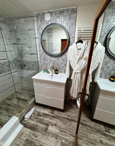 a bathroom with a shower and a sink and a mirror at Pensiunea PORTAS RESORT in Slănic