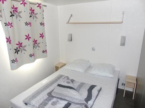 une chambre avec un lit et un rideau de douche dans l'établissement BONNES VACANCES sur le Camping LA PRAIRIE, à Saint-Hilaire-de-Riez