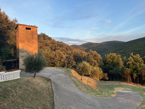 a winding road leading to a tower in the mountains at "Casa Parletto" - Villa Esclusiva con Piscina in Caldana
