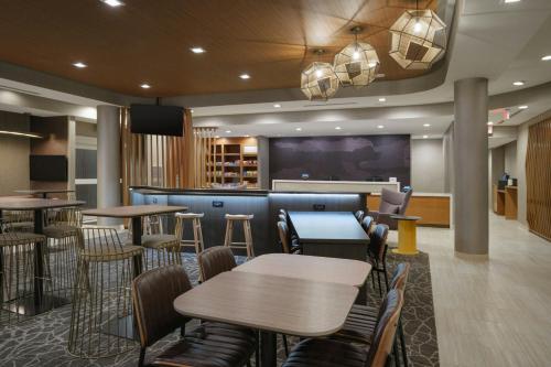 a restaurant with tables and chairs and a bar at SpringHill Suites by Marriott Lexington Frankfort in Frankfort