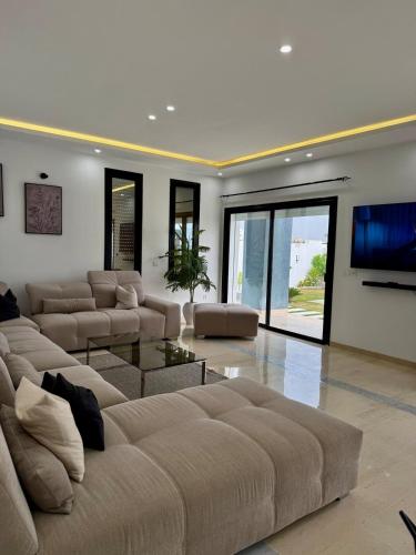 a large living room with couches and a flat screen tv at Villa ander in Hammamet