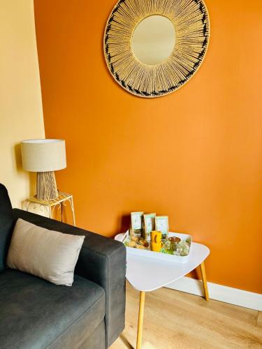a living room with a couch and a mirror at Gîte de l Archange in Josselin