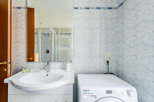 a bathroom with a sink and a washing machine at Residence Due Spade - Free Parking in Melzo