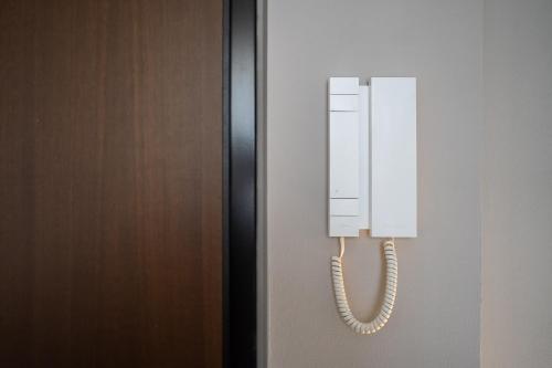 a white phone on a wall next to a door at Residence Due Spade - Free Parking in Melzo