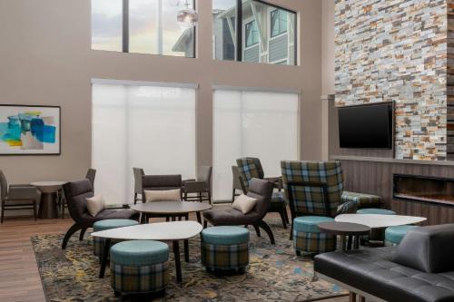 a waiting room with tables and chairs and a fireplace at Residence Inn by Marriott Novato Sonoma in Novato