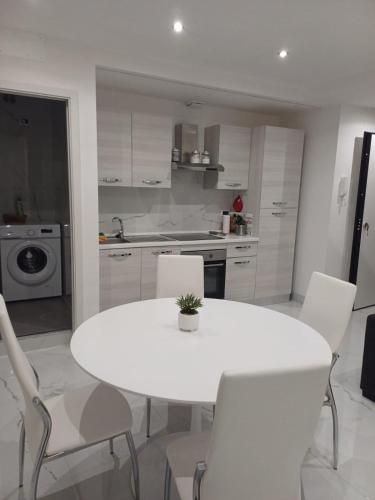 una cucina bianca con tavolo e sedie bianchi di 612 Flats a Roma