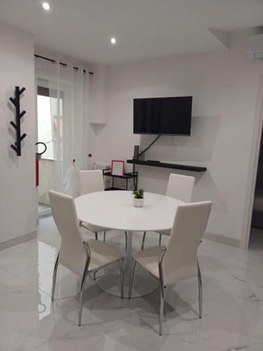 una sala da pranzo bianca con tavolo e sedie bianchi di 612 Flats a Roma