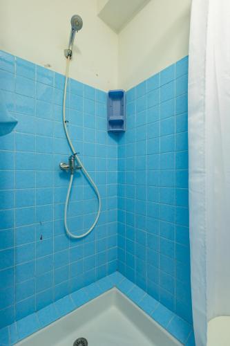 La salle de bains est pourvue de carrelage bleu, d'une douche et d'une baignoire. dans l'établissement Les Jacinthes - Spacious sea view, à Port-la-Nouvelle