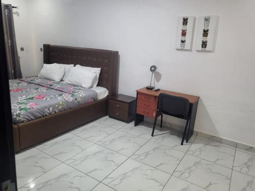 a bedroom with a bed and a desk with a lamp at Lekki chevron luxury in Lekki