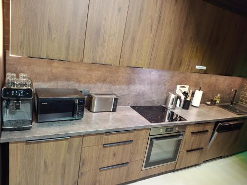 a kitchen with a counter top with a microwave at Ernests' unique townhouse with sauna, hot tub and free parking in Rīga