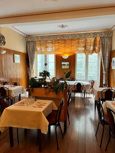 a restaurant with tables and chairs in a room at Hôtel Restaurant Les Arcades in Limoux