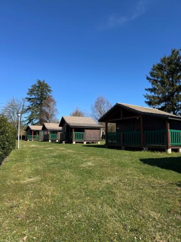 un groupe de bâtiments sur une prairie dans l'établissement Camping de Prémery Les prés de la ville, à Prémery