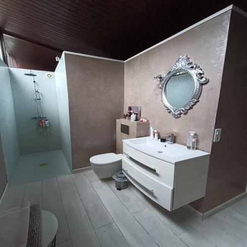 une salle de bain avec un lavabo, des toilettes et un miroir dans l'établissement L'Esprit Vintage, à Mérignac
