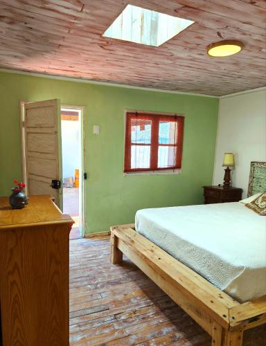ein Schlafzimmer mit einem Bett und einer Holzdecke in der Unterkunft Departamento Vintage in Colbún