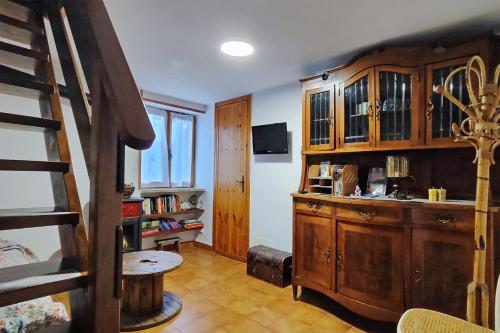 a living room with wooden cabinets and a staircase at Baita LA CANAL silenzio e relax in Monastero di Lanzo