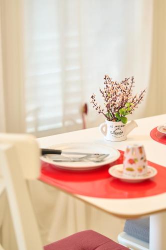 a table with plates and a vase of flowers on it at Il Fiore di Monnalisa in Vinci
