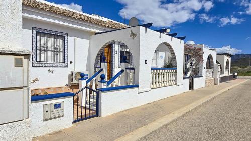 a white building with arches and a gate on a street at Villa Bonita in Mazarrón