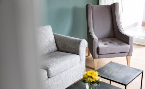 a living room with a chair and a table at Residenz Seeterrasse Restaurant & Hotel in Wangen