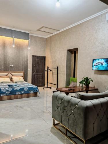 a bedroom with a bed and a couch in a room at Hotel Home in Tashkent