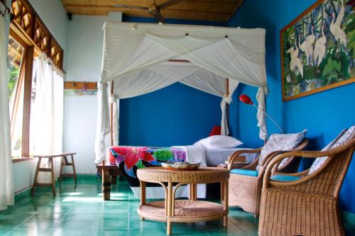 a bedroom with a bed with a canopy at Bebek Biru in Sidemen