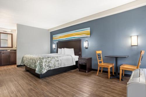 a hotel room with a bed and a table and chairs at HomeTowne Studios by Red Roof Montgomery - Midtown in Montgomery