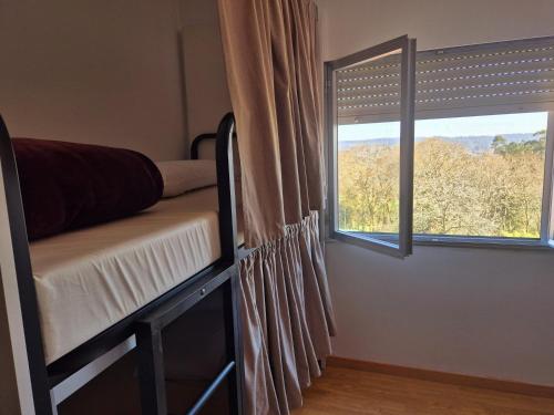 a bedroom with two bunk beds and a window at Albergue Alto da Pena EXCLUSIVE FOR PILGRIMS in Negreira