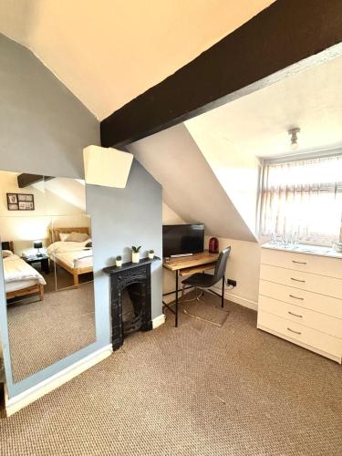 a bedroom with a bed and a desk with a fireplace at Summerfield House in Birmingham