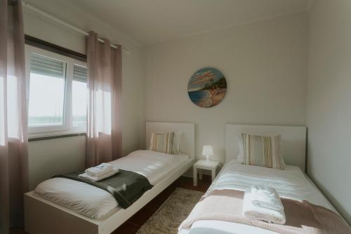 Dos camas individuales en una habitación con ventana. en Best Houses 115 - Faustino s House II, en Atouguia da Baleia