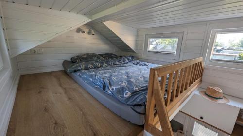 a small bedroom with a bed in a attic at Tinyhouse Bergharen in Bergharen