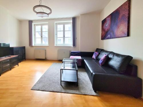 a living room with a black couch and a table at ShalalaLiving Apartments Mariazell in Mariazell
