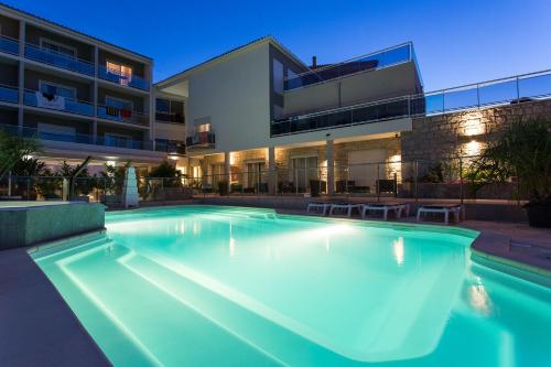 uma piscina em frente a um edifício em Hotel Revellata & Spa em Calvi