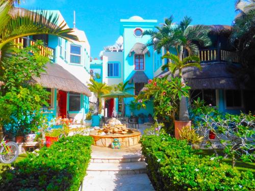 a garden in front of a house with palm trees at Casa Gatos in Akumal